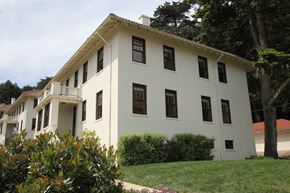 San Francisco triplex for rent - a white building with black windows and a lawn in front of it