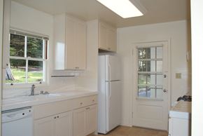 San Francisco triplex for rent - a kitchen with white cabinets and a white refrigerator