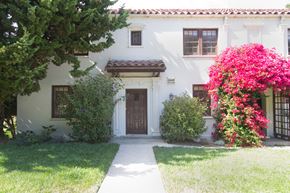 San Francisco triplex for rent - the front of a white house with a walkway and trees and flowers