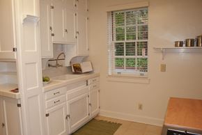 San Francisco triplex for rent - a kitchen with white cabinets and a sink and a window