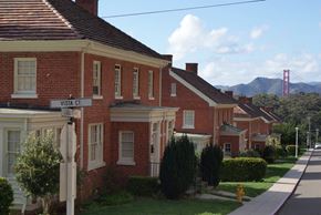 San Francisco triplex for rent - a row of houses on a street with a view of the golden gate bridge
