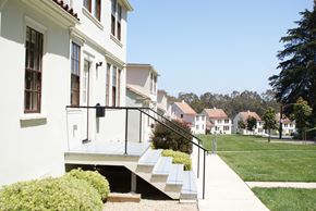 San Francisco apartment for rent - a row of white houses with stairs in front of a lawn and trees
