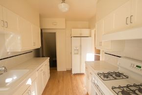 San Francisco triplex for rent - an empty kitchen with white appliances and white cabinets