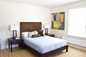 San Francisco triplex for rent - a bedroom with a bed and a painting on the wall
