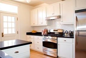 San Francisco triplex for rent - a kitchen with stainless steel appliances and white cabinets