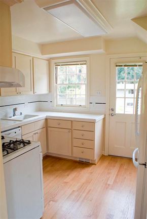San Francisco townhouse for rent - a kitchen with white cabinets and a stove and a window
