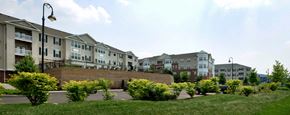 Royersford apartment for rent - an exterior view of an apartment complex with green grass and a brick wall