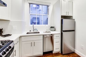 San Francisco apartment for rent - A kitchen with white cabinets and a stainless steel refrigerator.