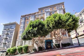 San Francisco apartment for rent - A tree in front of a building with a blue door.