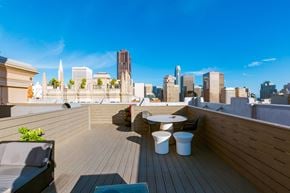 San Francisco apartment for rent - A rooftop patio with a table and chairs overlooking a city skyline.