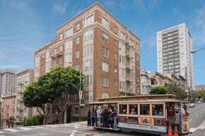 San Francisco apartment for rent - A trolley car is on a street in front of a brick building.