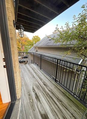 Chicago apartment for rent - a balcony with a wooden deck next to a building