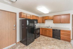 West Fargo apartment for rent - a kitchen with black appliances and wooden cabinets