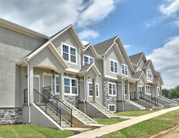 Olathe townhouse for rent - A row of houses with grey siding and white trim.