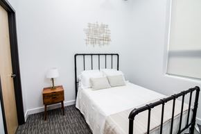 Sioux City apartment for rent - a bedroom with a white bed and a black metal bed frame