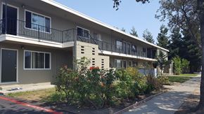 Sunnyvale apartment for rent - an apartment building with a garden in front of it