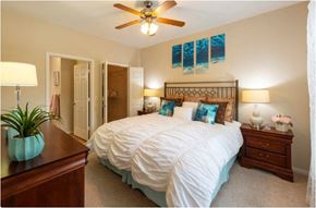 Houston apartment for rent - a bedroom with a large bed and a ceiling fan