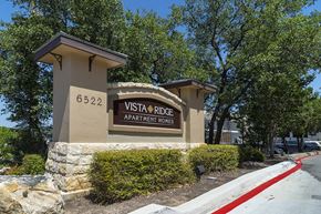 San Antonio apartment for rent - A sign for Vista Ridge Apartment Homes is displayed in front of a building.