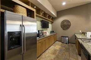 San Antonio apartment for rent - A modern kitchen with a stainless steel refrigerator and wooden cabinets.