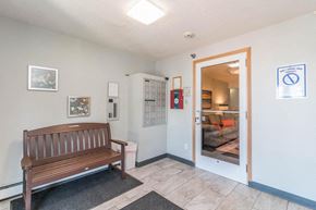 Melrose apartment for rent - A room with a bench and a door leading to a living room.