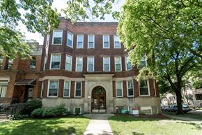 Chicago apartment for rent - a brick building with a lawn and trees in front of it