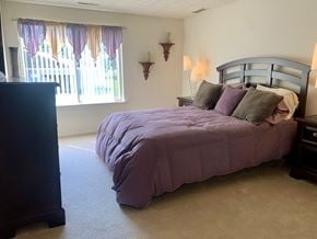Fairport townhouse for rent - a bedroom with a bed and a window with curtains