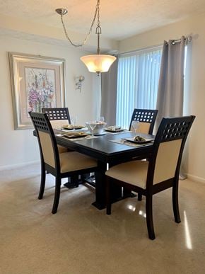 Fairport townhouse for rent - a dining room with a table and chairs and a window