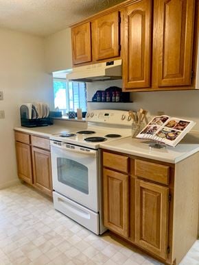 Fairport townhouse for rent - a kitchen with a stove and cabinets and a magazine on the counter