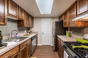Okemos townhouse for rent - A kitchen with wooden cabinets and a black stove top.