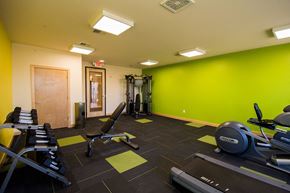 Sun Prairie apartment for rent - a gym with exercise equipment and a green wall