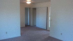 Seaside apartment for rent - A room with a carpet floor and a doorway leading to another room.