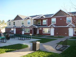 St Cloud townhouse for rent - a group of houses with a patio and picnic tables in front of them