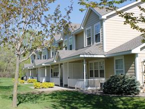 Mahtomedi apartment for rent - a row of houses with a lawn and trees