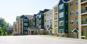 Maple Grove apartment for rent - Apartment complex with green and beige buildings.