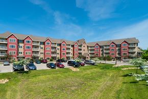 Plymouth apartment for rent - an exterior view of an apartment building with a parking lot
