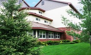 St Cloud apartment for rent - A house with a red roof and white walls with windows.