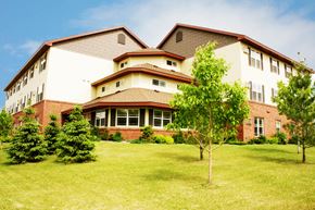 St Cloud apartment for rent - A large, multi-story building with a red brick exterior and a white trim.