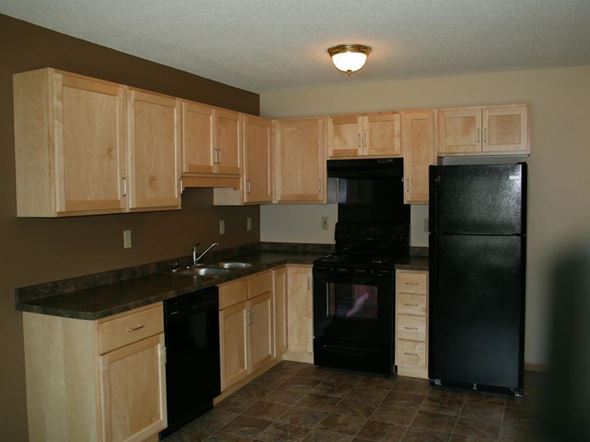 St Cloud townhouse for rent - a kitchen with black appliances and wooden cabinets