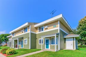 Albany townhouse for rent - the front of a green house with a lawn and a blue sky