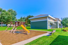 Albany townhouse for rent - a playground with a swing set in front of a house