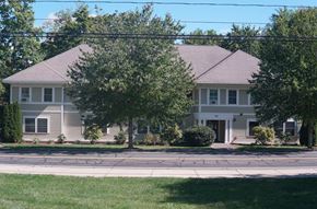 Northampton apartment for rent - A house with a grey roof and a tree in front of it.