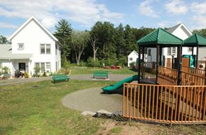 Amherst apartment for rent - a playground with benches and a swing set in front of houses