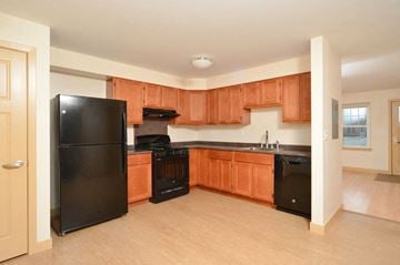 Easthampton apartment for rent - a kitchen with black appliances and wooden cabinets