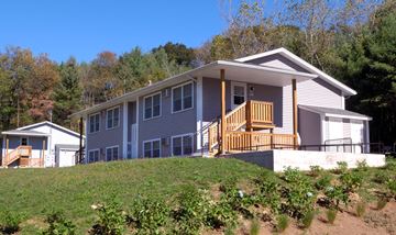 Charlton apartment for rent - a gray house with a wooden porch on a hill