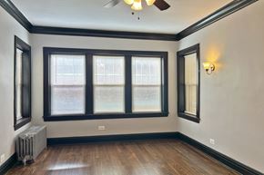 Oak Park apartment for rent - A room with a ceiling fan, two windows, and a radiator.