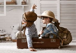 San Antonio apartment for rent - Two children are sitting in a suitcase, one wearing a cowboy hat and the other wearing a bear hat.