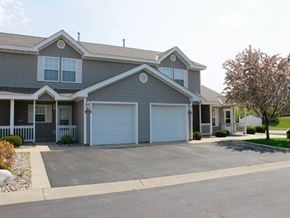 Shakopee apartment for rent - a blue house with two garage doors on a driveway