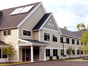 Saco apartment for rent - A modern house with a brown roof and a red door.