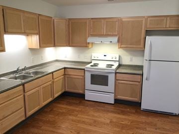 South Berwick apartment for rent - A kitchen with wooden cabinets and a white fridge.