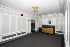 San Francisco apartment for rent - A white room with a fireplace and a chandelier.